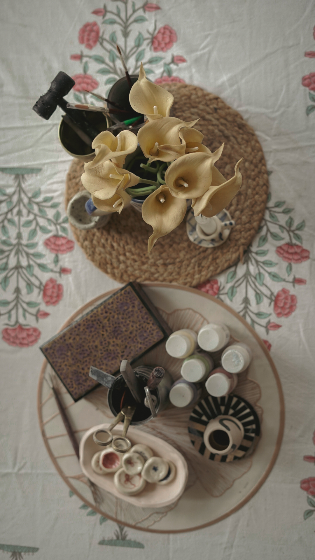 Pottery tools, lilies, and glaze bottles laid out